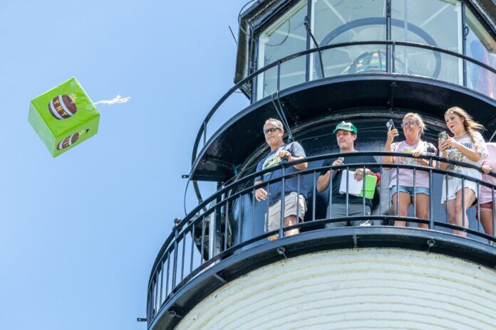 Key West Key Lime Pie Drop 2023 NWM-6919 Large a group of people standing on top of a light house