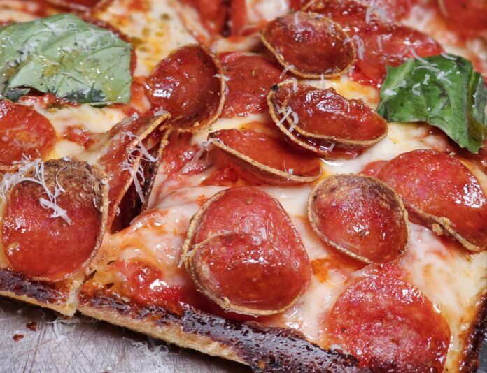a close up of a slice of pepperoni pizza