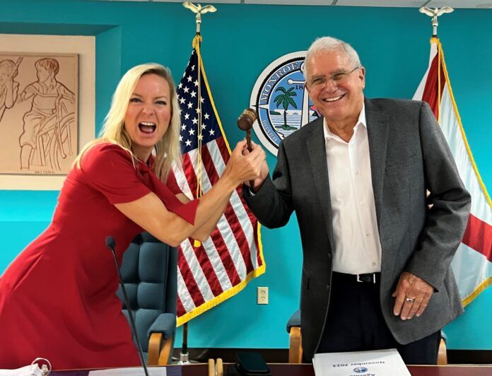 Gavel Passing a man and woman shaking hands in front of flags