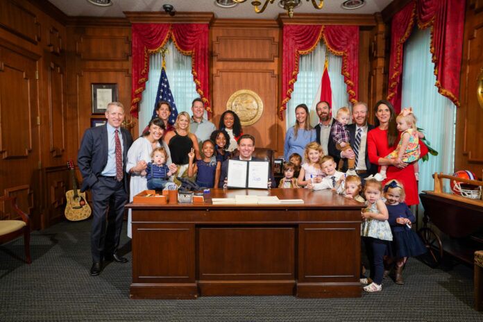 Governor tax relief bill a group of people standing in front of a desk