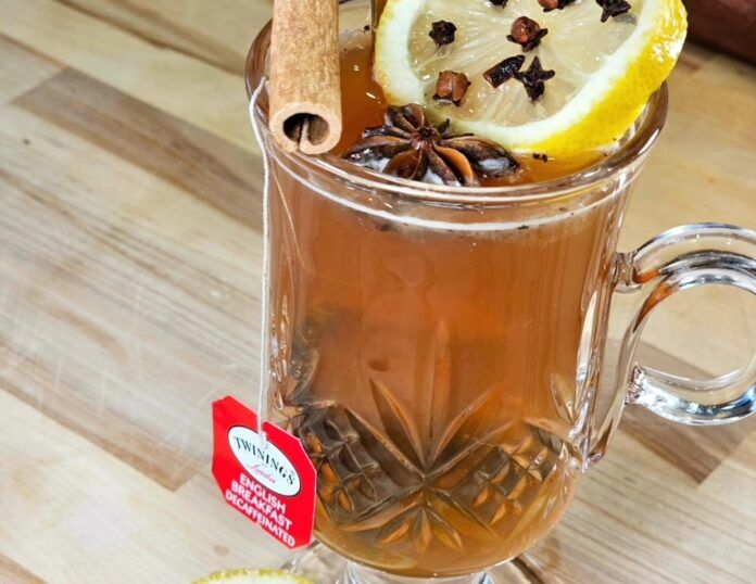 Hot toddy a cup of tea with a lemon slice and cinnamon