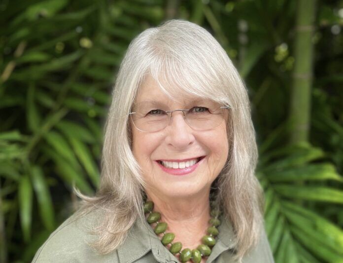 a woman wearing glasses and a green shirt