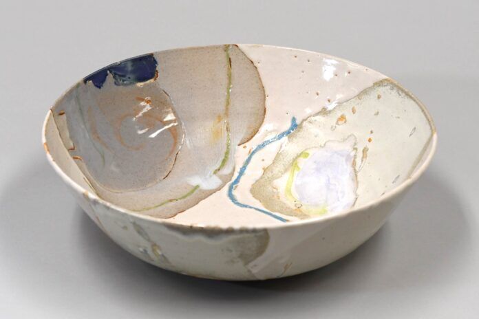 a white bowl with blue and yellow designs on it