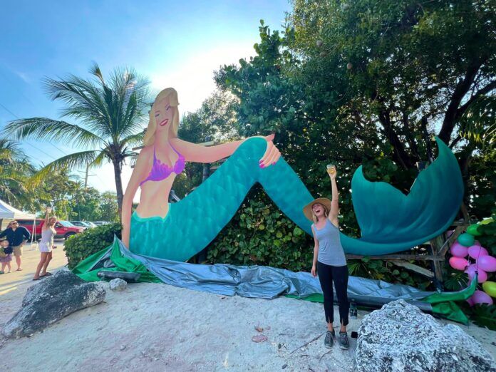Jul with Lorelei a woman standing in front of a mermaid statue