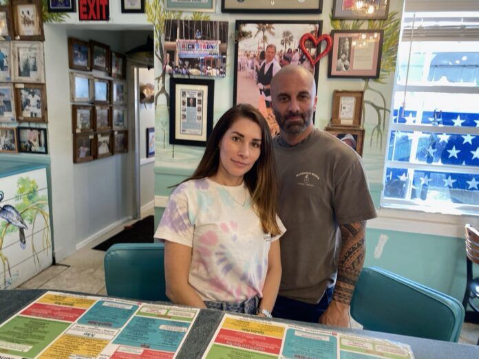 a man and a woman standing in front of a table