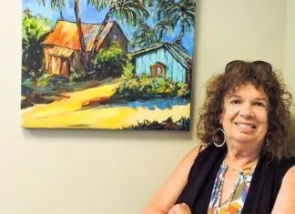 ARTIST’S CORNER: KEY LARGO’S GLORIA AVNER DISCOVERS BATIK WITH A TWIST a woman standing in front of a painting