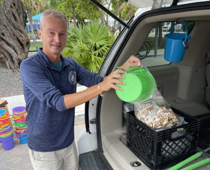 kevin cig butts a man standing next to a car filled with items