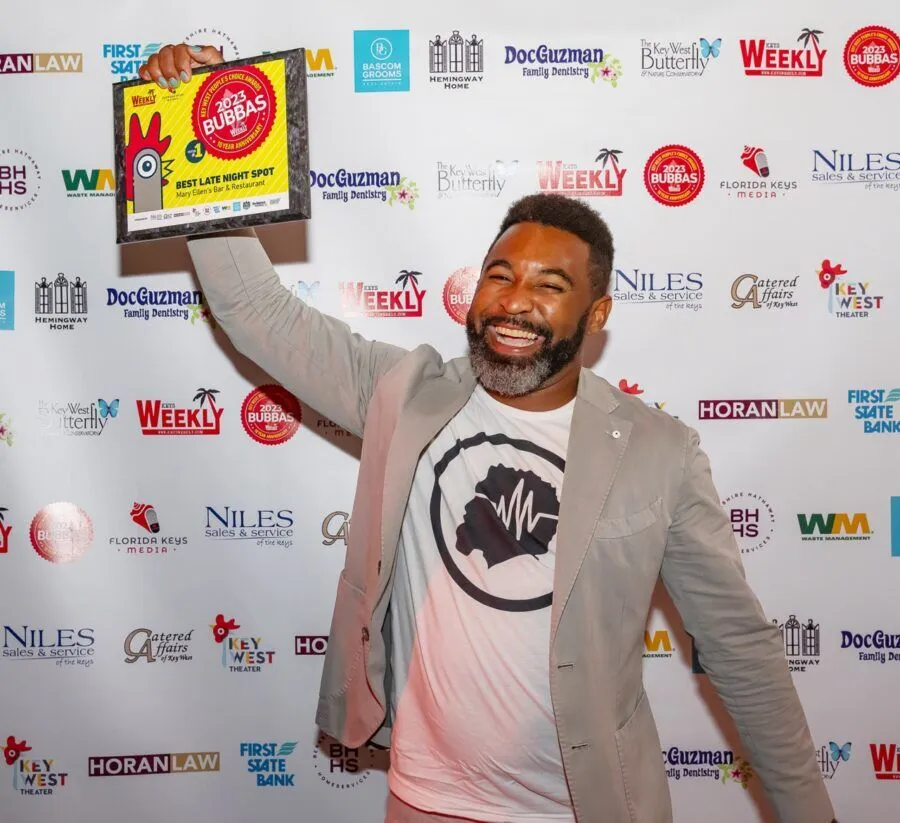 a man holding up a sign in front of a red carpet