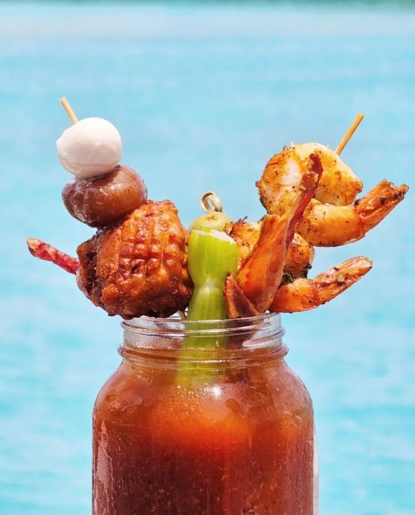 a mason jar filled with food next to a body of water