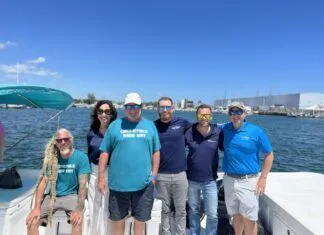 IT TAKES AN ARMY — TO CLEAN UP KEYS WATERS a group of people on a boat posing for a picture