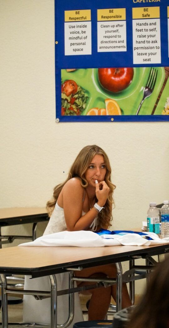 a woman sitting at a table in a classroom