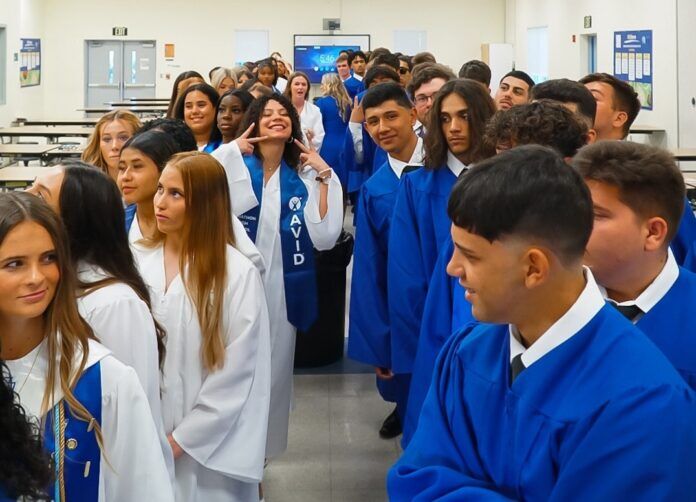 a large group of people in blue graduation gowns