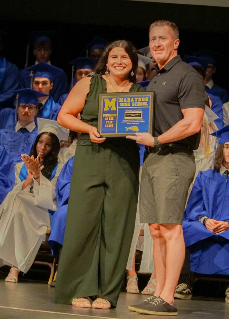 a man standing next to a woman on top of a stage