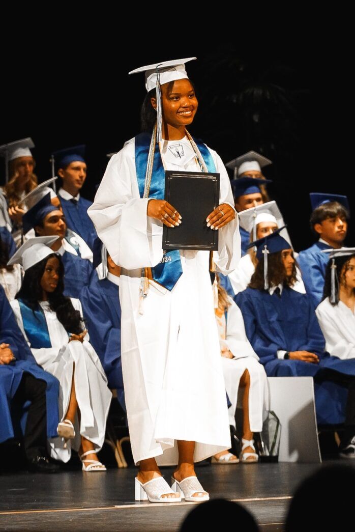 a woman in a graduation gown holding a book