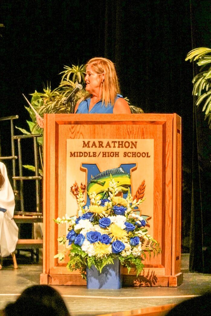 a woman standing at a podium in front of a crowd
