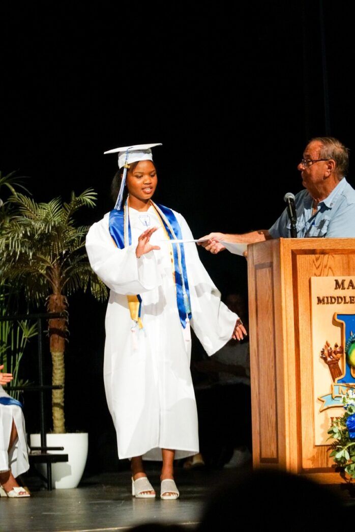 a woman in a graduation gown standing at a podium