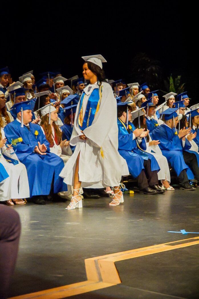 a group of people in graduation gowns sitting on a stage