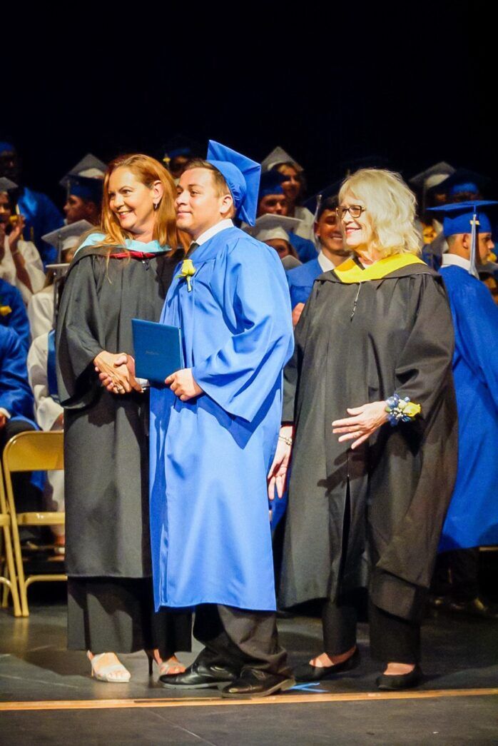 a group of people in graduation gowns standing on a stage