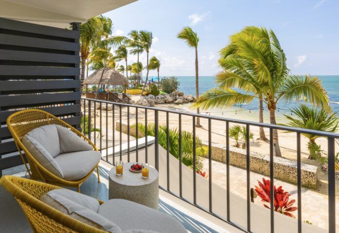 Three Waters Resort Large a balcony with wicker furniture and a view of the beach
