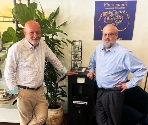 two men standing next to each other in an office