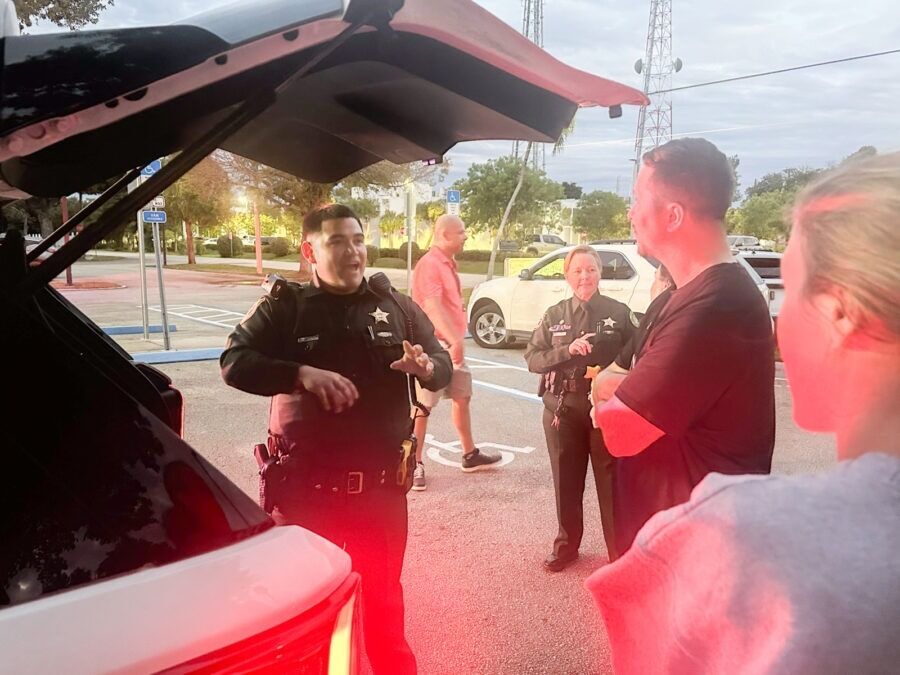 a group of police officers standing around a car