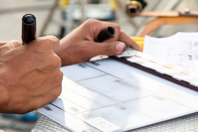 a person holding a pen and writing on a piece of paper