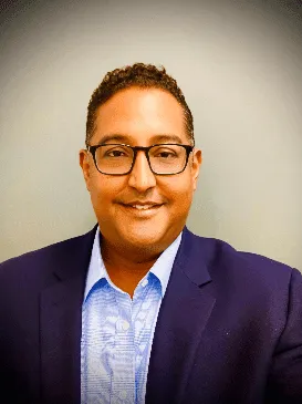 a man wearing glasses and a purple jacket