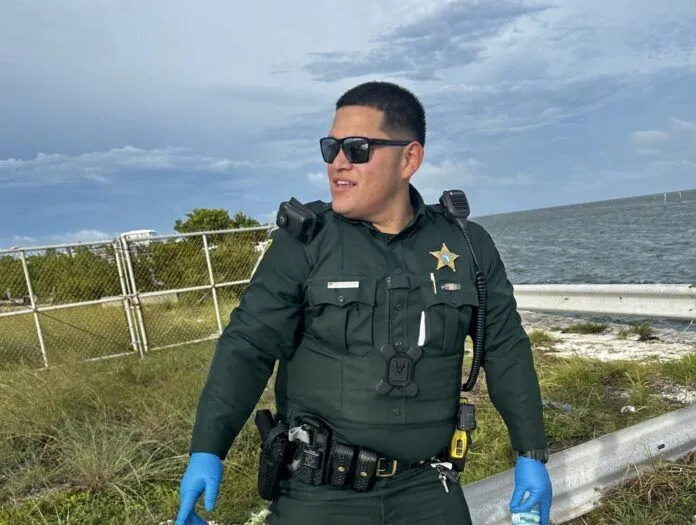 unnamed a man in a police uniform standing next to a fence