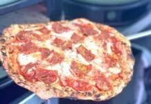 a person holding a pizza in their hand
