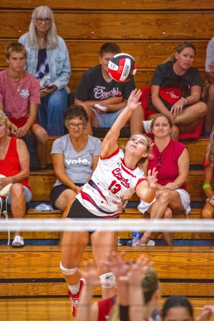 a woman hitting a volleyball over the net