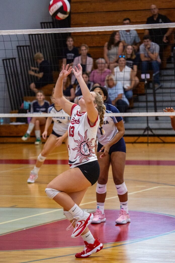 a group of young women playing a game of volleyball