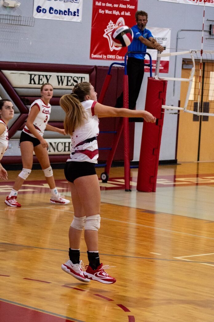 a group of young women playing a game of volleyball