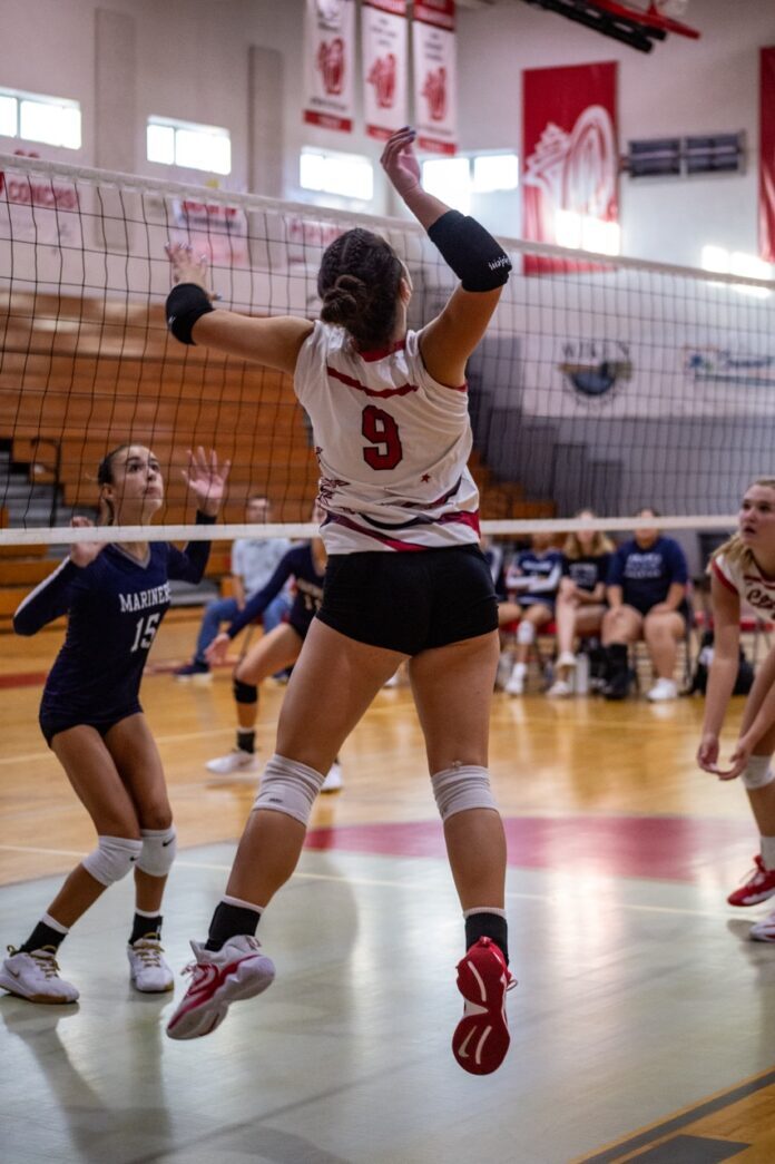 a group of young women playing a game of volleyball