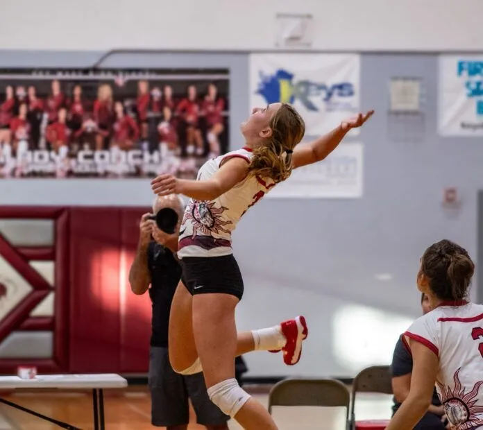 5(1) Large a woman jumping up to hit a volleyball
