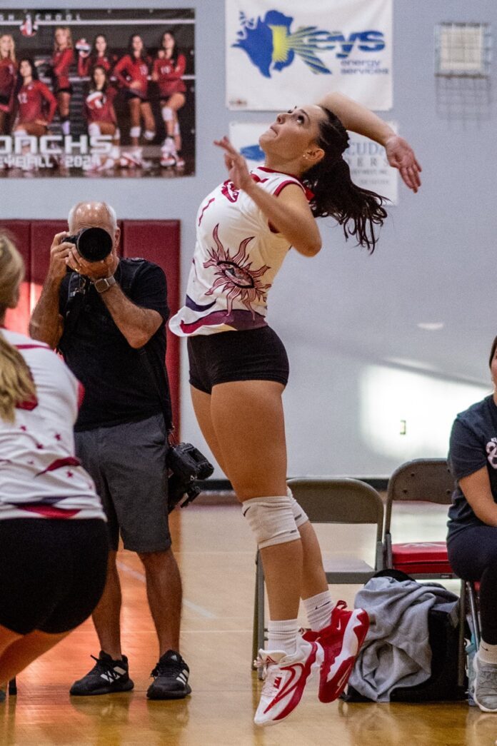 a woman jumping up in the air to catch a ball