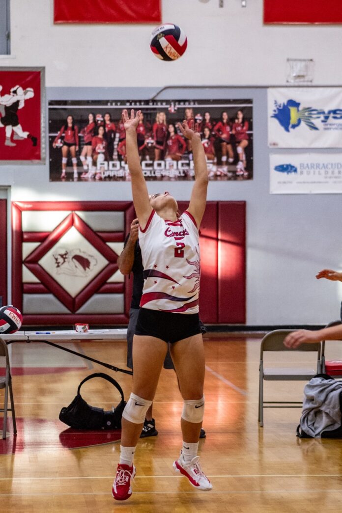 a volleyball player jumping up to hit the ball