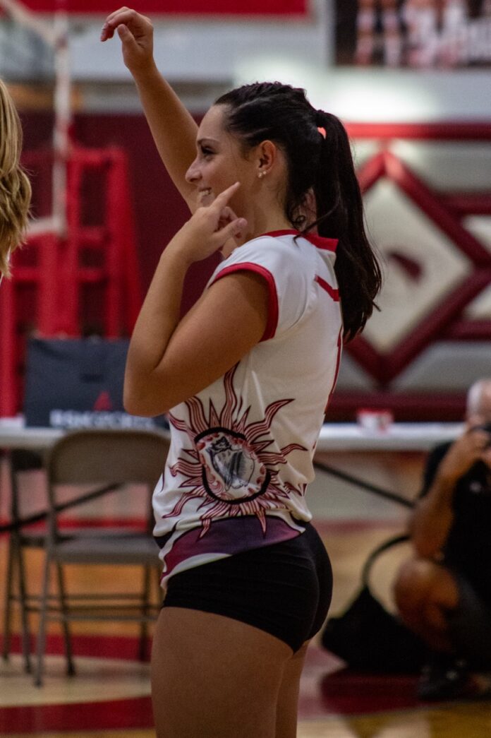 two girls playing volleyball in a gym