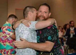 BEST OF MARATHON: ANDY SHARF IS MARATHON’S PHILANTHROPIST OF THE YEAR a couple of men hugging each other on a dance floor