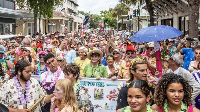 Buffett parade packed Large a large group of people walking down a street