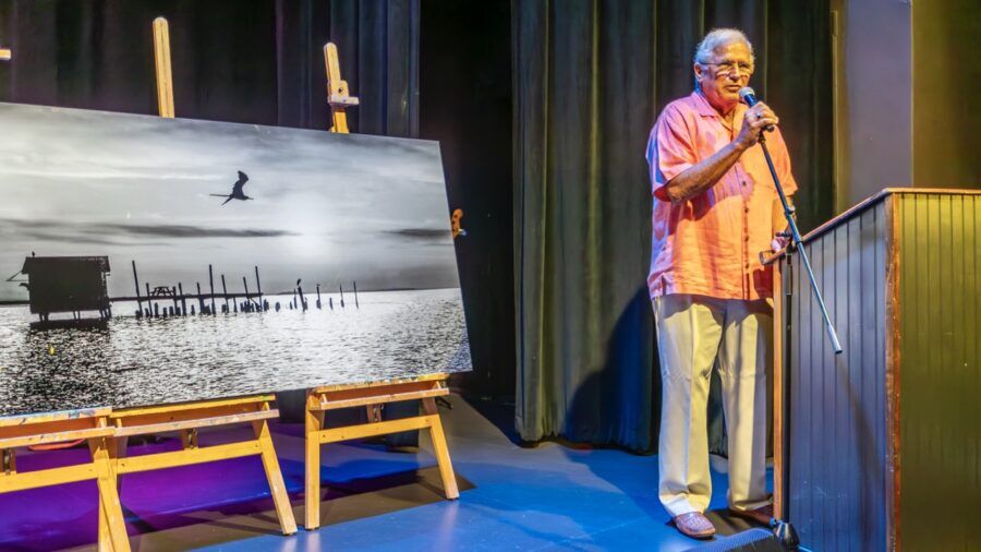 a man standing in front of a painting on a stage