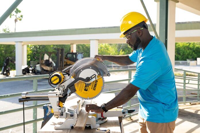 a man using a circular saw to cut a piece of wood