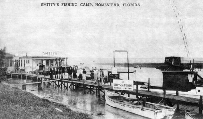 Smitty's Fish Camp a black and white photo of a boat docked at a pier