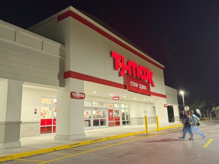 TJ Maxx Large a store front at night with people walking by