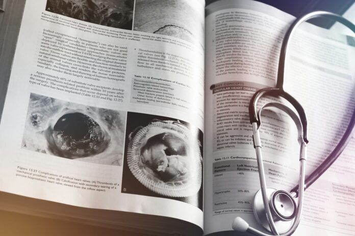 Photo by Abdulai Sayni a medical book with a stethoscope on top of it
