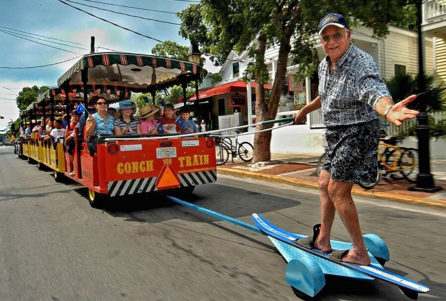 a man on a skateboard being pulled by a train