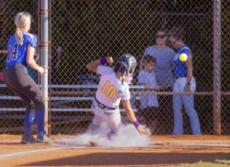 a softball player sliding into home plate during a game