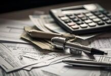 STORM SEASON PREP: IS YOUR WALLET READY FOR THE NEXT DISASTER? a calculator and a pen on top of a pile of papers