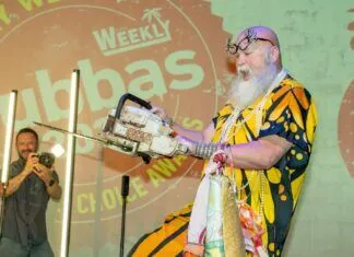 2025 BUBBAS BRING OUT THE BEST OF KEY WEST; $40,000 RAISED FOR KEYS AHEC a man standing on a stage with a saw