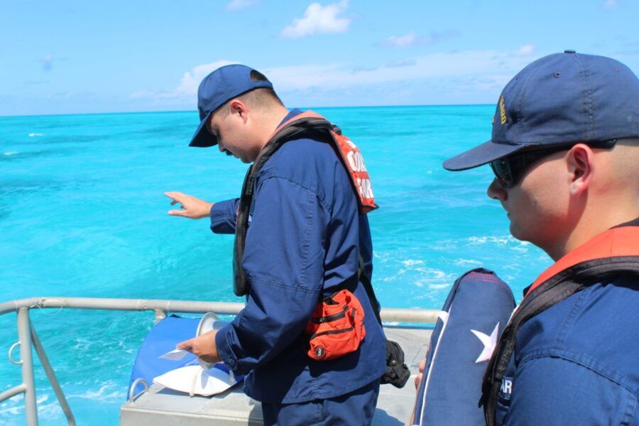 two men standing on a boat in the ocean