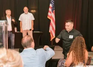 FIRST-TIME AWARD WINNERS BRING SPECIAL MEANING TO BEST OF MARATHON a group of people sitting around a table
